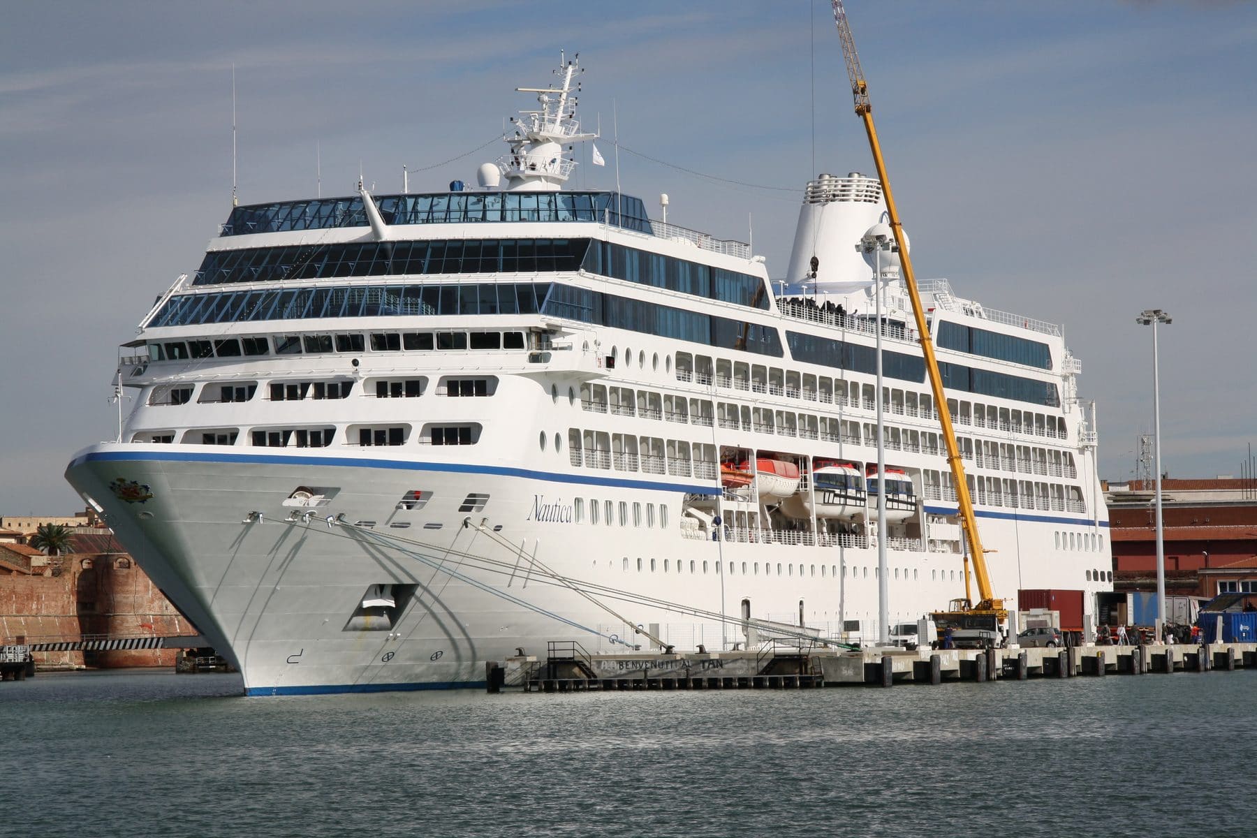 Oceania's Nautica, one of the smaller R-class ships, alongside in port with a dockside crane