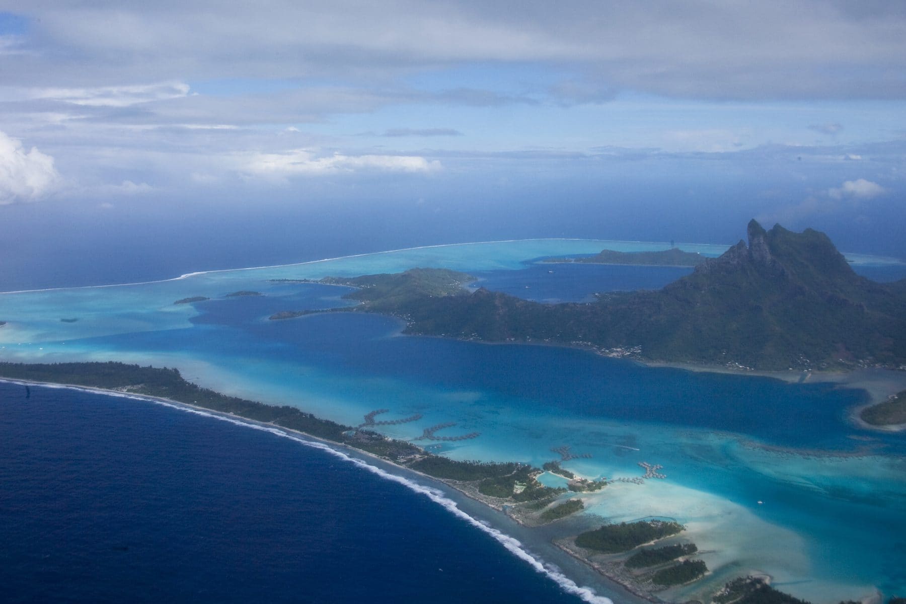 The lagoon of Bora Bora in shades of turquoise beneath Mount Otemanu