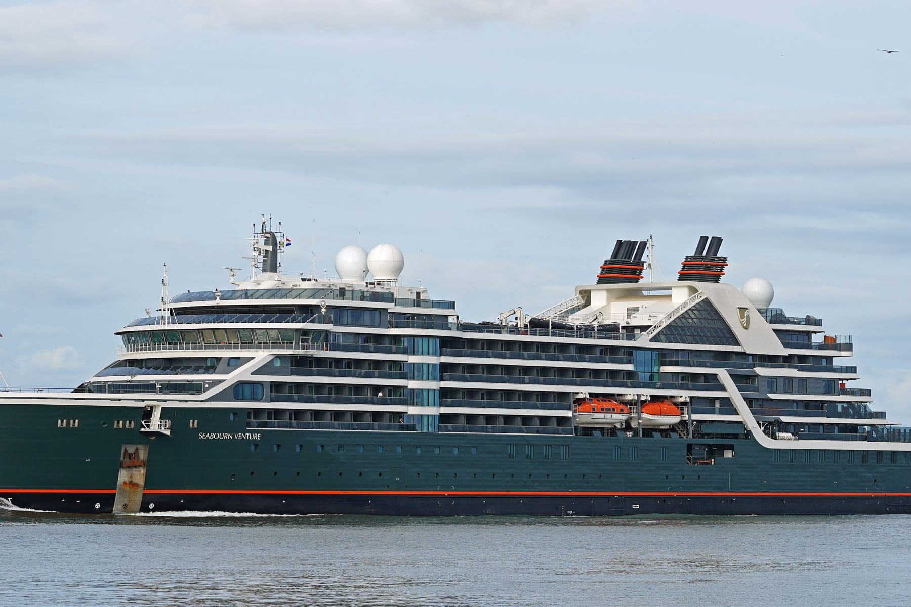 Seabourn Venture, the dark-hulled expedition ship, under way on gray water